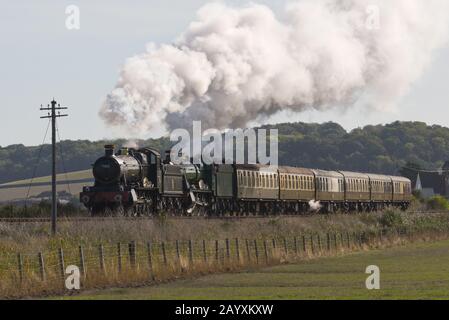 Un train à tête double comprenant 6960 Raveningham Hall et 7822 Foxcote Manor tirant une pluie vers Minehead sur le West Somerset Railway. Banque D'Images