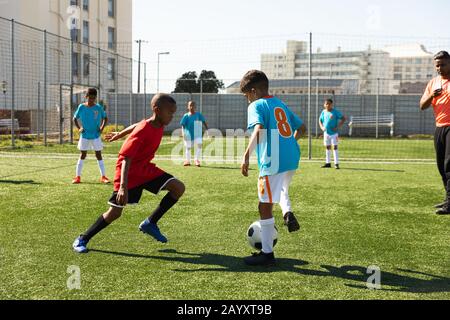 Les enfants s'entrainement pour jouer au football sur le terrain Banque D'Images