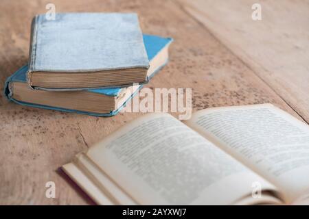 vieux livres recouverts de papier et un ouvert sur une table en bois avec espace de copie Banque D'Images