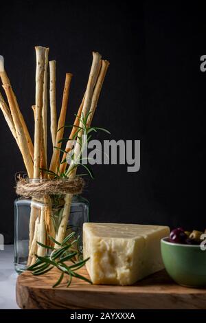 Bâtonnets de pain en-cas Grissini et fromage Asiago aux olives. Banque D'Images