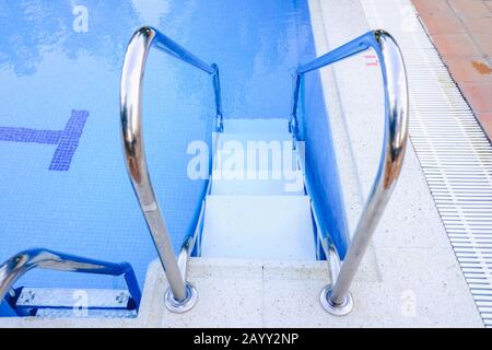 Escalier pour entrer et sortir d'une piscine. Banque D'Images