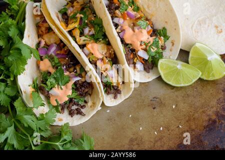 Tacos au bœuf coréen : cuisine fusion coréenne-mexicaine - Tacos faite de bœuf haché et surmontée de coriandre, kimchi et mayonnaise à la sriracha Banque D'Images