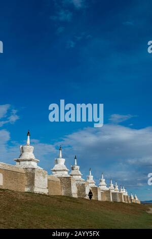Un homme mongol marche le long du mur avec des stupas qui entoure le monastère d'Erdene Zuu à Kharakhorum (Karakorum), en Mongolie. Banque D'Images