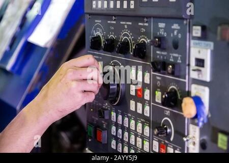 Poignée de manœuvre de rotation manuelle de l'opérateur sur le panneau de commande de la machine CNC. Gros plan avec mise au point sélective et flou. Banque D'Images