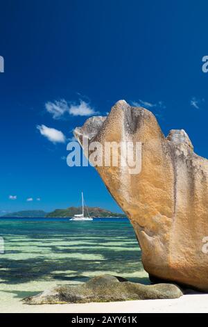 Glacis autostable rockformation et voilier sur l'île de Curieuse, Seychelles. Ile Praslin en arrière-plan Banque D'Images