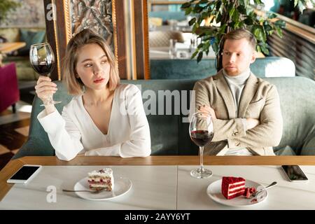 Photo horizontale de la femme pleine de ressentiment qui dit quelque chose à l'homme avec qui elle rencontre un conflit pendant qu'elle a la date Banque D'Images