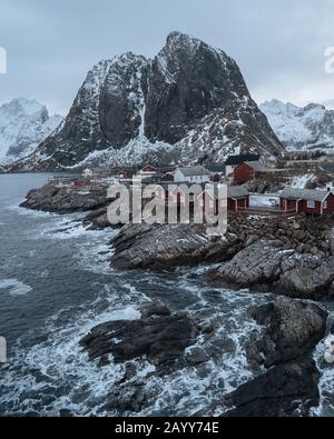 Célèbre attraction touristique Hamnoy village de pêcheurs sur les îles Lofoten, Norvège. Maisons de rorbuer rouges traditionnelles avec chute de neige en hiver au coucher du soleil Banque D'Images