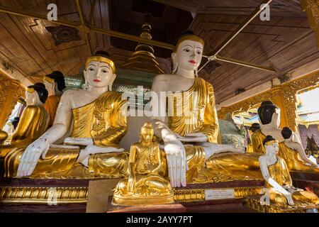 De nombreuses statues de Bouddha assis de différentes tailles à la pagode Shwedagon à Yangon, au Myanmar, en journée. Banque D'Images