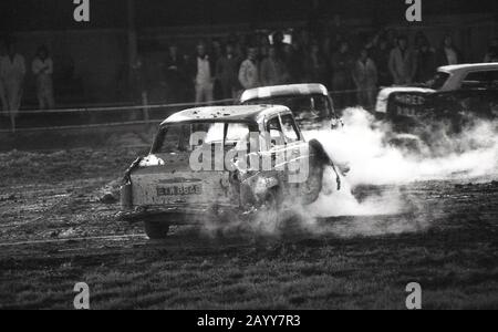 Années 1970, historique, une voiture de course banger avec de la fumée qui coule d'un moteur battue, Angleterre, Royaume-Uni. Dans les courses de banners, de vieilles voitures de ferraille sont utilisées et le contact avec les voitures de crash et les dommages des voitures d'opposants est autorisé, ce qui entraîne une collision de voitures coincées sur le circuit. Banque D'Images