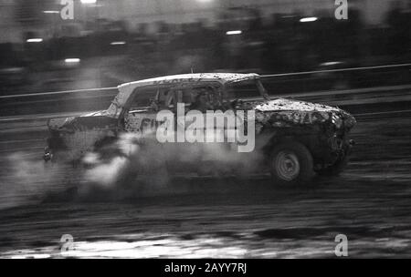 Années 1970, historique, une voiture de course banger avec de la fumée qui coule d'un moteur battue, Angleterre, Royaume-Uni. Dans les courses de banners, de vieilles voitures de ferraille sont utilisées et le contact avec les voitures de crash et les dommages des voitures d'opposants est autorisé, ce qui entraîne une collision de voitures coincées sur le circuit. Banque D'Images