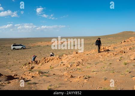 Touristes à la recherche de fossiles de dinosaures aux falaises de Flaming dans le désert de Gobi près de Bulgan dans le sud de la Mongolie. Banque D'Images