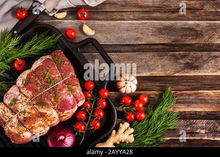 Viande de porc crue aux épices, prête à cuire, sur fond sombre, vue de dessus avec espace de copie Banque D'Images