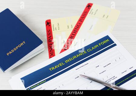 Formulaire de demande d'assurance voyage avec carte d'embarquement et passeport sur table en bois blanc. Concept de politique de voyage. Banque D'Images