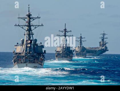 Le porte-avions nucléaires de classe Nimitz de la Marine américaine USS Theodore Roosevelt est suivi en formation de trois destroyers de missiles guidés de classe Arleigh Burke lorsqu'il transite l'Océan Pacifique le 25 janvier 2020 dans l'Océan Pacifique. Banque D'Images