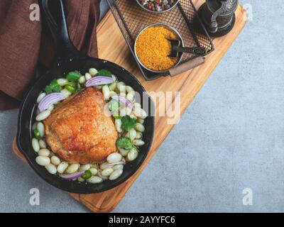 cuisse de poulet cuite avec haricots blancs dans une poêle Banque D'Images