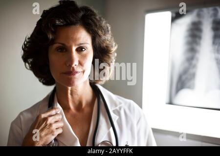 Portrait d'une femme médecin debout devant une radiographie. Banque D'Images
