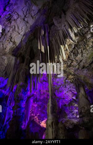 Des lumières colorées illuminent les stalactites et les stalagmites dans la grotte de St. Michael's, un réseau de grottes calcaires situées dans le Haut-Rock Natur Banque D'Images