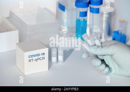 Kit de test de coronavirus COVID-19, nouveau et rapide. Kit de diagnostic pcr 2019 nCoV. Mains dans le gant avec la boîte. Le kit RT-PCR détecte le virus covid19 chez les patients atteints de sam Banque D'Images