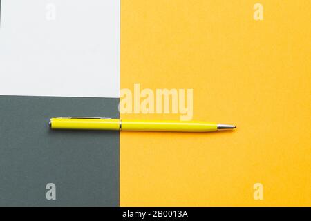 Stylo jaune et note blanche sur fond coloré Banque D'Images