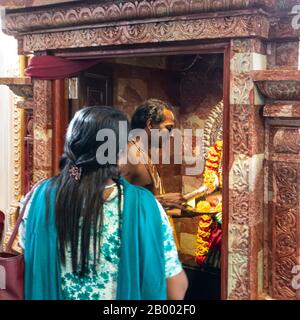 Singapour. Janvier 2020. Une femme prie devant l'autel dans un temple hindou Banque D'Images