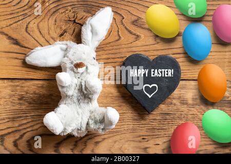 Lapin farci avec message « Hapy Easter » sur fond en bois Banque D'Images