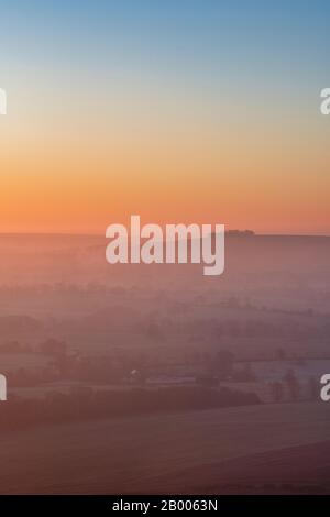 Vue de Martinsell Hill sur un matin d'hiver brumeux au lever du soleil. Près De Oare, Vale Of Pewsey, Wiltshire, Angleterre Banque D'Images