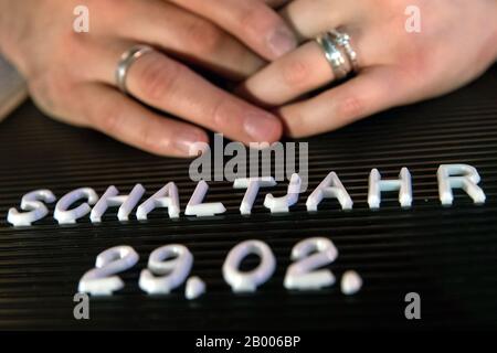 Nuremberg, Allemagne. 17 février 2020. Un couple avec des anneaux de mariage place leurs mains sur un tableau d'écriture avec l'inscription 'Leap année - 29.02.'. De nombreux couples ont choisi le 29 février 2020 comme date de leur cérémonie de mariage - une date qui n'est possible que tous les quatre ans de l'année bissextile. (À dpa: 'Jour de mariage pour les paresseux - 29 février') crédit: Daniel Karmann/dpa/Alay Live News Banque D'Images