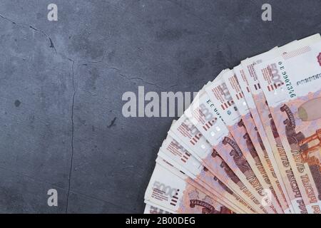 Pile de billets de l'argent russe de cinq mille roubles couché ventilateur sur une base de ciment gris Banque D'Images
