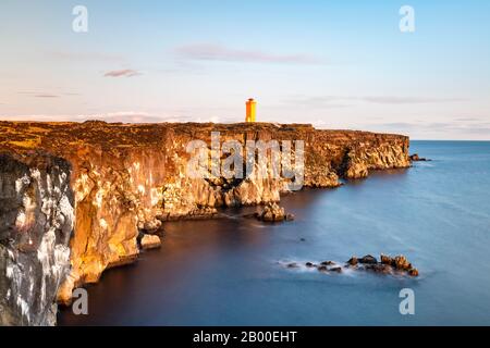 Le phare orange d'Oendverdarnes se trouve sur la côte de la falaise, sur la côte rocheuse de la roche de lave, sur une longue période d'exposition, à Oendveroarnes, à Snaefellsjoekull National Banque D'Images