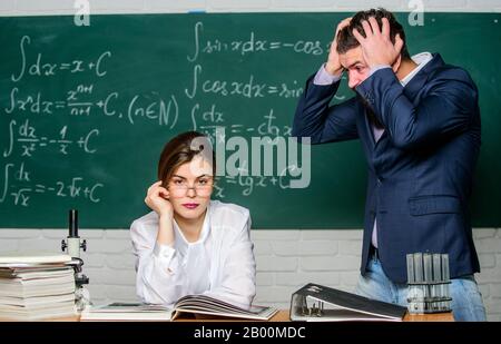 Homme mécontent de communiquer. Le directeur de l'école parle de punition. Enseignant homme barbu strict ayant un conflit avec la fille étudiante. Situation de conflit. Conflit scolaire. Chargé de cours exigeant. Banque D'Images