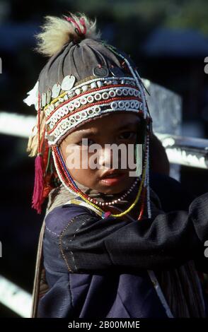 Thaïlande: Un enfant Akha dans le chapeau traditionnel, province de Chiang Rai. Les Akha sont une tribu de collines de fermiers de subsistance connus pour leur art. Le groupe ethnique a peut-être été originaire de Mongolie il y a environ 1500 ans. La plupart des Akha restants sont maintenant répartis dans de petits villages parmi les montagnes de Chine, du Laos, du Myanmar (Birmanie) et du nord de la Thaïlande, où ils sont l'une des six principales tribus de colline. L'Akha a commencé à arriver en Thaïlande au début du XXe siècle et continue d'immigrer, avec environ 80,000 000 vivant actuellement dans les provinces du nord de la Thaïlande, à savoir Chiang Rai et Chiang Mai. Banque D'Images