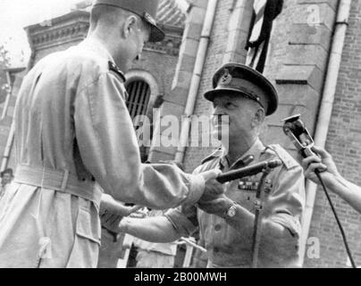 Vietnam : le général britannique Sir Douglas David Gracey (1894–1964) cède l'autorité au général français Philippe Leclerc, à l'extérieur de la cathédrale de Saigon, 1945. En septembre 1945, Gracey a dirigé 20,000 soldats de la 20e division indienne pour occuper Saigon. Lors de la Conférence de Potsdam en juillet 1945, les alliés avaient convenu que la Grande-Bretagne prenait le contrôle du Vietnam au sud du 16e parallèle des occupants japonais. Les Français, désireux de conserver leur colonie, ont persuadé le commandant en chef de Gracey, Lord Mountbatten, d'autoriser Gracey à déclarer la loi martiale. Banque D'Images