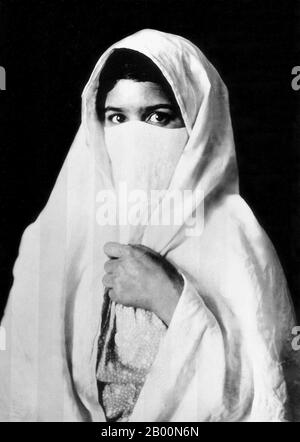 Algérie : musulmane voilée, début du XXe siècle. Photographie d'une femme voilée - vraisemblablement arabe ou bédouine - d'Algérie produite comme souvenir pour le marché touristique européen naissant. Banque D'Images