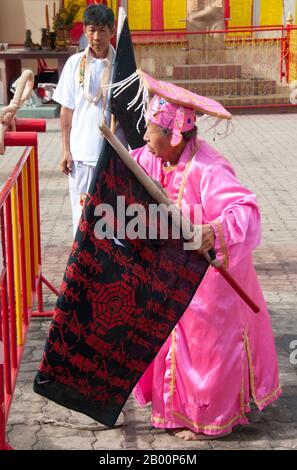 Thaïlande: Une femme âgée 'ma Song' (dévot entrée) revient à San Chao Chui Tui (temple taoïste chinois) de la parade, Festival végétarien de Phuket. Le Festival végétarien est un festival religieux qui se tient chaque année sur l'île de Phuket dans le sud de la Thaïlande. Il attire des foules de spectateurs en raison de nombreux rituels religieux inhabituels qui sont exécutés. Beaucoup de dévotés religieux se slaleront avec des épées, perce leurs joues avec des objets pointus et commettent d'autres actes douloureux. Banque D'Images