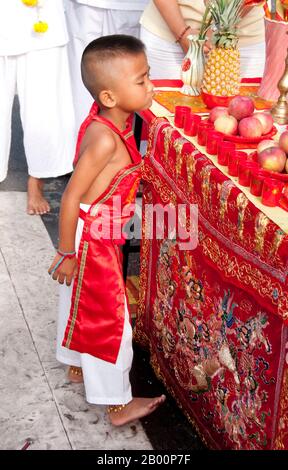 Thaïlande: Un très jeune dévot dans une transe à un autel de rue, Festival végétarien de Phuket. Le Festival végétarien est un festival religieux qui se tient chaque année sur l'île de Phuket dans le sud de la Thaïlande. Il attire des foules de spectateurs en raison de nombreux rituels religieux inhabituels qui sont exécutés. Beaucoup de dévotés religieux se slaleront avec des épées, perce leurs joues avec des objets pointus et commettent d'autres actes douloureux. Banque D'Images