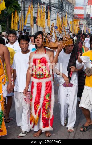 Thaïlande: Le dévot ou 'ma Song' participe à une procession à travers la ville de Phuket, Festival végétarien de Phuket. Le Festival végétarien est un festival religieux qui se tient chaque année sur l'île de Phuket dans le sud de la Thaïlande. Il attire des foules de spectateurs en raison de nombreux rituels religieux inhabituels qui sont exécutés. Beaucoup de dévotés religieux se slaleront avec des épées, perce leurs joues avec des objets pointus et commettent d'autres actes douloureux. Banque D'Images