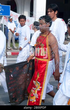 Thaïlande: Le dévot ou 'ma Song' participe à une procession à travers la ville de Phuket, Festival végétarien de Phuket. Le Festival végétarien est un festival religieux qui se tient chaque année sur l'île de Phuket dans le sud de la Thaïlande. Il attire des foules de spectateurs en raison de nombreux rituels religieux inhabituels qui sont exécutés. Beaucoup de dévotés religieux se slaleront avec des épées, perce leurs joues avec des objets pointus et commettent d'autres actes douloureux. Banque D'Images