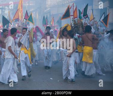 Thaïlande: Les porteurs de sanctuaire font la course dans les rues pour éviter l'explosion des pétards et le bruit assourdissant, Festival végétarien de Phuket. Le Festival végétarien est un festival religieux qui se tient chaque année sur l'île de Phuket dans le sud de la Thaïlande. Il attire des foules de spectateurs en raison de nombreux rituels religieux inhabituels qui sont exécutés. Beaucoup de dévotés religieux se slaleront avec des épées, perce leurs joues avec des objets pointus et commettent d'autres actes douloureux. Banque D'Images