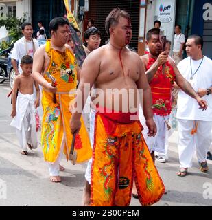 Thaïlande: Le dévot ou 'ma Song' participe à une procession à travers la ville de Phuket, Festival végétarien de Phuket. Le Festival végétarien est un festival religieux qui se tient chaque année sur l'île de Phuket dans le sud de la Thaïlande. Il attire des foules de spectateurs en raison de nombreux rituels religieux inhabituels qui sont exécutés. Beaucoup de dévotés religieux se slaleront avec des épées, perce leurs joues avec des objets pointus et commettent d'autres actes douloureux. Banque D'Images