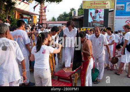 Thaïlande : la cérémonie 'traverser le pont' à San Chao Bang Niew (temple taoïste chinois), Festival végétarien de Phuket, est un rituel de purification. Le Festival végétarien est un festival religieux qui a lieu chaque année sur l'île de Phuket dans le sud de la Thaïlande. Il attire des foules de spectateurs en raison de la plupart des rituels religieux inhabituels qui sont effectués. Beaucoup de dévots religieux se coupent avec des épées, perdent leurs joues avec des objets pointus et commettent d'autres actes douloureux. Banque D'Images