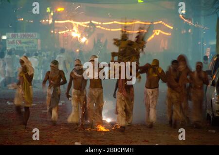 Thaïlande: Les porteurs de sanctuaire font la course dans les rues dans la parade de nuit, Festival végétarien de Phuket. Le Festival végétarien est un festival religieux qui se tient chaque année sur l'île de Phuket dans le sud de la Thaïlande. Il attire des foules de spectateurs en raison de nombreux rituels religieux inhabituels qui sont exécutés. Beaucoup de dévotés religieux se slaleront avec des épées, perce leurs joues avec des objets pointus et commettent d'autres actes douloureux. Banque D'Images