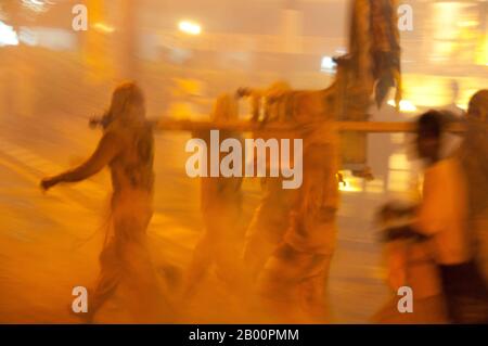 Thaïlande: Les porteurs de sanctuaire font la course dans les rues dans la parade de nuit, Festival végétarien de Phuket. Le Festival végétarien est un festival religieux qui se tient chaque année sur l'île de Phuket dans le sud de la Thaïlande. Il attire des foules de spectateurs en raison de nombreux rituels religieux inhabituels qui sont exécutés. Beaucoup de dévotés religieux se slaleront avec des épées, perce leurs joues avec des objets pointus et commettent d'autres actes douloureux. Banque D'Images