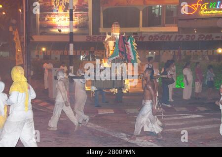 Thaïlande: Les porteurs de sanctuaire font la course dans les rues dans la parade de nuit, Festival végétarien de Phuket. Le Festival végétarien est un festival religieux qui se tient chaque année sur l'île de Phuket dans le sud de la Thaïlande. Il attire des foules de spectateurs en raison de nombreux rituels religieux inhabituels qui sont exécutés. Beaucoup de dévotés religieux se slaleront avec des épées, perce leurs joues avec des objets pointus et commettent d'autres actes douloureux. Banque D'Images