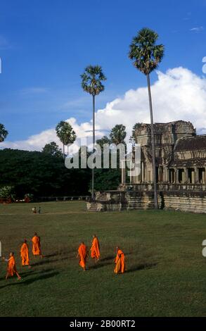 Cambodge: Moines quittant le sanctuaire central à Angkor Wat. Angkor Wat a été construit pour le roi Suryavarman II (gouverné 1113-50) au début du XIIe siècle comme son temple d'état et capitale. En tant que temple le mieux préservé du site d'Angkor, il est le seul à être resté un important centre religieux depuis sa fondation – d'abord hindou, dédié au dieu Vishnu, puis bouddhiste. C'est le plus grand bâtiment religieux au monde. Le temple est au sommet du style classique élevé de l'architecture khmère. Il est devenu un symbole du Cambodge, apparaissant sur son drapeau national. Banque D'Images