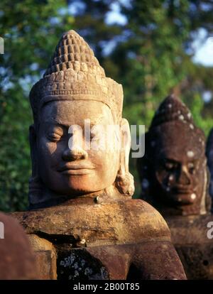 Cambodge: Devas (divinités bienveillantes ou anges) bordant la route de la porte Sud, Angkor Thom. Les Devas sont souvent vus en opposition à Asura (déités pécheresses). Angkor Thom est situé à 1,5 km au nord d'Angkor Wat. Il a été construit à la fin du XIIe siècle par le roi Jayavarman VII, et couvre une superficie de 9 km², à l'intérieur desquels sont situés plusieurs monuments des époques antérieures ainsi que ceux établis par Jayavarman et ses successeurs. On croit qu'il a soutenu une population de 80,000 à 150,000 personnes. Au centre de la ville se trouve le temple d'état de Jayavarman, le Bayon. Banque D'Images