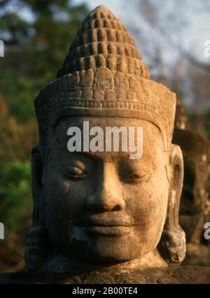 Cambodge: Devas (divinités bienveillantes ou anges) bordant la route de la porte Sud, Angkor Thom. Les Devas sont souvent vus en opposition à Asura (déités pécheresses). Angkor Thom, signifiant "la Grande ville", est situé à un mile au nord d'Angkor Wat. Il a été construit à la fin du XIIe siècle par le roi Jayavarman VII, et couvre une superficie de 9 km², à l'intérieur desquels sont situés plusieurs monuments des époques antérieures ainsi que ceux établis par Jayavarman et ses successeurs. On croit qu'il a soutenu une population de 80,000 à 150,000 personnes. Au centre de la ville se trouve le temple d'état de Jayavarman, le Bayon. Banque D'Images