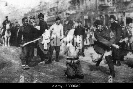 Chine : exécution de rue par décapitation d'un communiste chinois par des soldats de droite, Shanghai, 1927. La terreur de Shanghai : en 1927, les communistes tentèrent de mettre fin au régime étranger, officiellement soutenu par les gangsters et les nationalistes du Kuomintang (KMT). Les dirigeants de la bande verte ont cependant conclu des alliances informelles avec Chiang Kai-shek et les capitalistes de Shanghailander ont agi contre les communistes et les syndicats organisés. Les nationalistes avaient coopéré avec les chefs de gangs depuis la révolution de 1911. De nombreux communistes ont été tués lors d'une attaque surprise de gangster majeure en avril 1927 à Shanghai. Banque D'Images