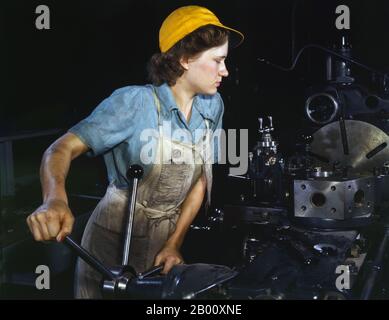 USA: Une vraie vie 'Rosie le Riveter' - l'opérateur de tour de Turret usant des pièces pour les avions de transport à l'usine de Consolidated Aircraft Corporation, fort Worth, Texas. Photo de Howard R. Hollem (-1949), 1942. « Rosie le Riveter » est une icône culturelle des États-Unis représentant les américaines qui ont travaillé dans les usines pendant la Seconde Guerre mondiale; beaucoup ont travaillé dans des usines de fabrication qui ont produit des munitions et des fournitures de guerre. Ces femmes ont parfois pris des emplois entièrement nouveaux en remplacement des hommes qui étaient dans l'armée. Le personnage est considéré comme une icône féministe aux États-Unis et ailleurs. Banque D'Images