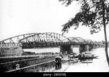 Vietnam : le pont de Trung Tien à six travées, qui s'étend sur la rivière des parfums (Song Huong) à Hue (début du XXe siècle). La rivière des parfums traverse la ville de Hue dans la province vietnamienne centrale de Thua Thien Hue. À l'automne, les fleurs des vergers en amont tombent dans l'eau, ce qui lui donne une odeur aromatique, d'où le nom de 'Perfume River'. La rivière des parfums a deux sources, toutes deux commençant dans la chaîne de montagne de Day Truong son et se rencontrent à Bang Lang Fork. La rivière de 30 km passe par les sites du temple Hon Chen et du temple Ngoc Tran. Banque D'Images