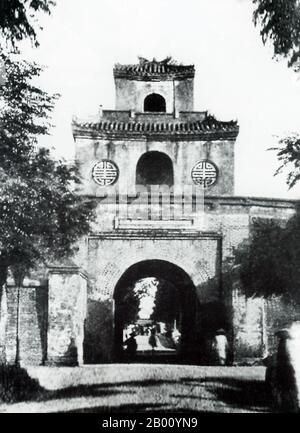 Vietnam: L'ancienne porte menant de la Citadelle impériale au marché de Dong Ba, Hue (début du XXe siècle). La ville impériale de Hue était entourée d'un mur de 2 x 2 km, et le mur était entouré d'une lande. L'eau de la lande a été extraite de la rivière Huong (rivière des parfums) qui traverse Hue. Cette structure est appelée la citadelle. En juin 1802, Nguyen Phuc Anh prend le contrôle du Vietnam et se proclame l'empereur Gia long. Son règne a été reconnu par la Chine en 1804, la même année la construction a commencé sur le nouveau palais et la citadelle. Banque D'Images